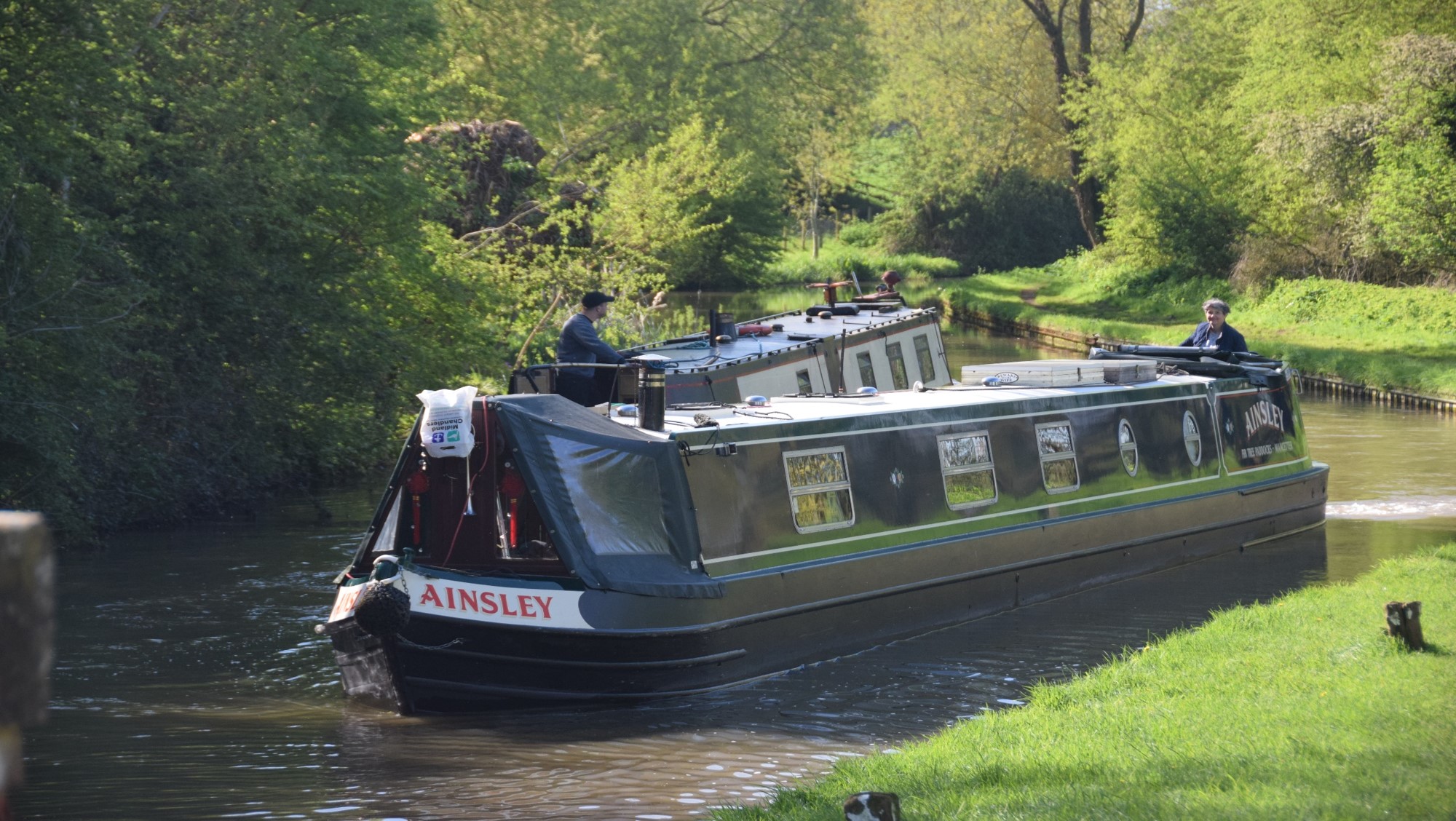 Two boats passing each other in a narrow canal