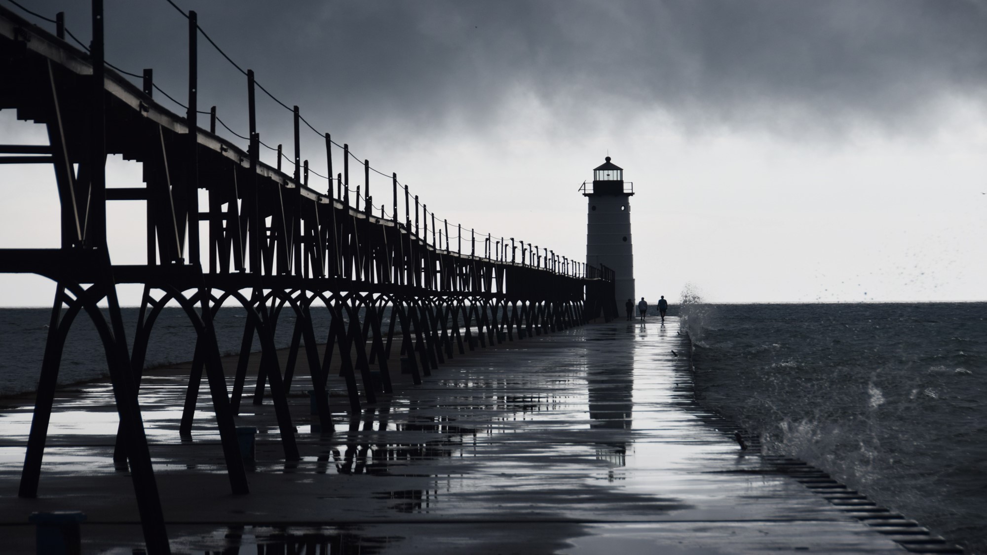 A lighthouse silouheted against a stormy sky - showing reflections